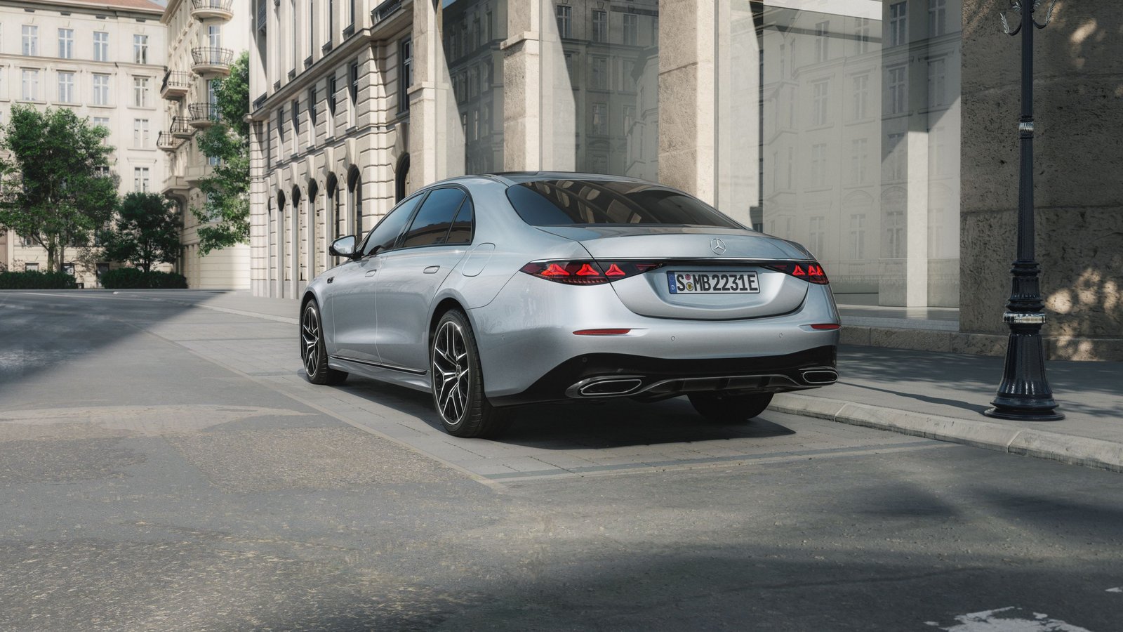 Silberne Limousine der Mercedes-Benz S-Klasse von hinten rechts vor einem historischen Gebäude in der Stadt